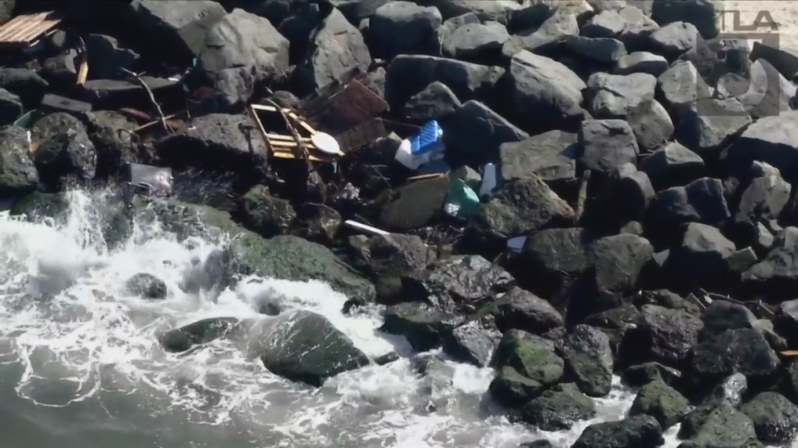 Debris is seen on rocks in Seal Beach on Aug. 23, 2023. (KTLA)