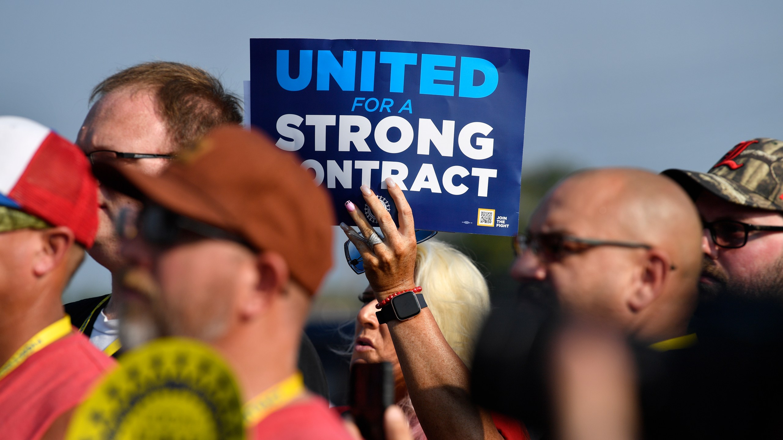 File - A member holds up a sign at a rally by United Auto Workers Local 863 in Louisville, Ky., on Aug. 24, 2023. eaders of the UAW union are considering targeted strikes at a small number of factories run by each of Detroit’s three automakers if they can’t reach contract agreements by a Thursday night, Sept. 12 deadline. (AP Photo/Timothy D. Easley, File)