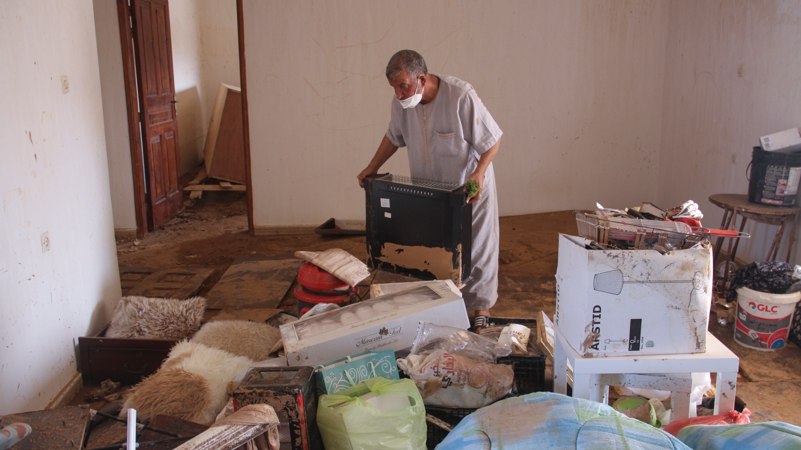 Derna flood survivor Abdul Salam Anwisi cleans his home after flooding caused by Mediterranean storm Daniel, in Derna, Libya, Sunday, Sept. 17, 2023. Anwisi said he woke up at one-thirty in the morning to a scream from outside, to find his neighbours' homes flooded with water. He, his sons, and other neighbours rushed to rescue the stranded families by pulling them from the roof of their house. Thousands of Libyans have lost family members, friends and neighbors in the devastating floods that engulfed the country's east. (AP Photo/Yousef Murad)