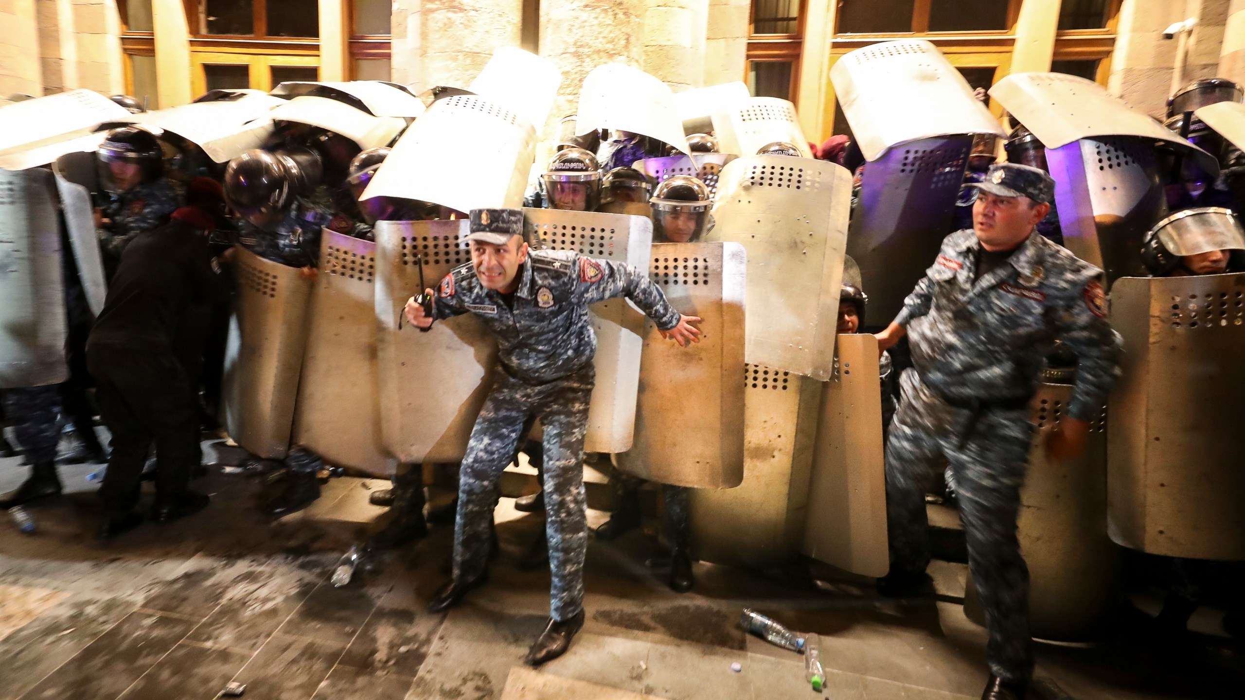 Police officers try to block an entrance of the government building during a protest against Prime Minister Nikol Pashinyan in Yerevan, Armenia, on Wednesday, Sept. 20, 2023. Protesters gathered in central Yerevan, the capital of Armenia, blocking streets and demanding that authorities defend Armenians in Nagorno-Karabakh. (Vahram Baghdasaryan/Photolure via AP)