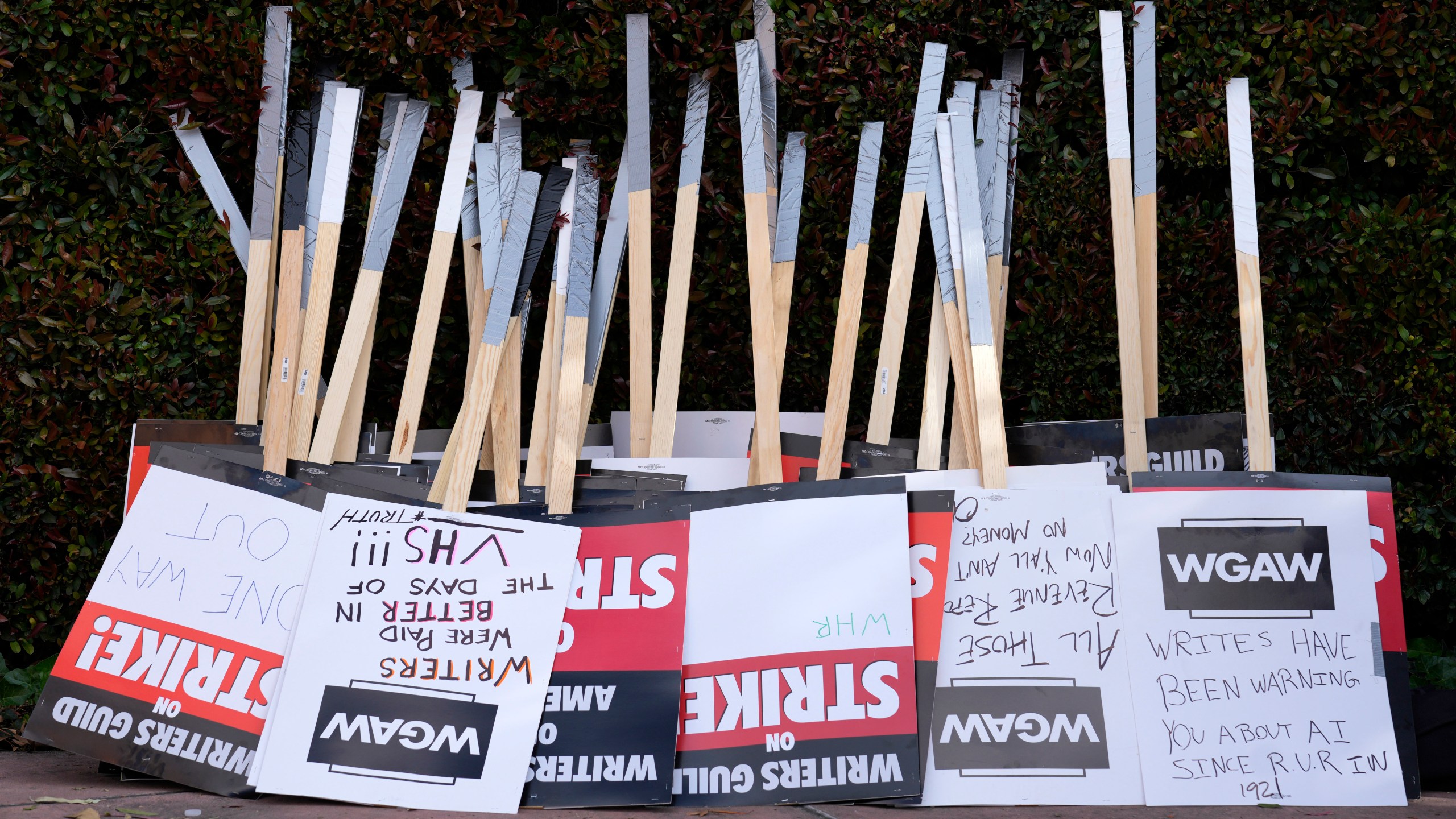 FILE - Placards are gathered together at the close of a picket by members of The Writers Guild of America outside Walt Disney Studios, Tuesday, May 2, 2023, in Burbank, Calif. On Sunday, Sept. 24, 2023, a tentative deal was reached to end Hollywood’s writers strike after nearly five months. (AP Photo/Chris Pizzello, File)