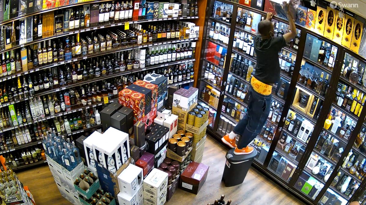 Security video captured a thief escaping with a $1,000 bottle of liquor during a violent confrontation at a liquor store in Calabasas on Aug. 31, 2023. (Malibu Liquor and Wine)