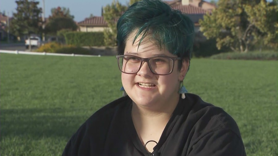 Pride flags being handed out by Moxxie, a 16-year-old high school student in Temecula, to his classmates in protest of the school district’s flag ban policy. (KTLA)