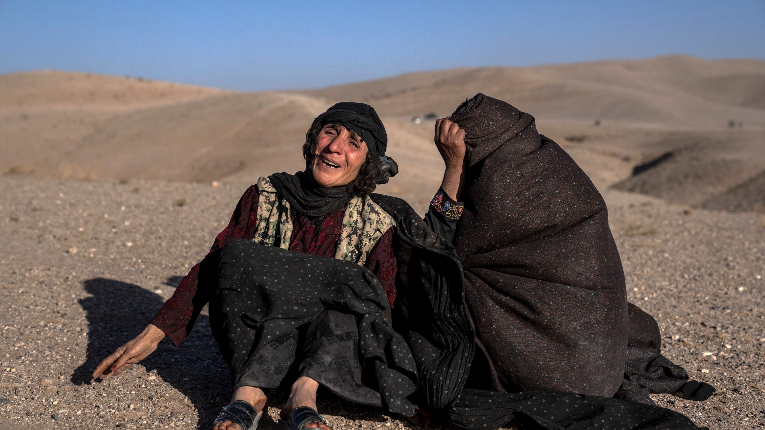 Afghan women mourn relatives killed in an earthquake at a burial site after an earthquake in Zenda Jan district in Herat province, western of Afghanistan, Sunday, Oct. 8, 2023. Powerful earthquakes killed at least 2,000 people in western Afghanistan, a Taliban government spokesman said Sunday. It's one of the deadliest earthquakes to strike the country in two decades. (AP Photo/Ebrahim Noroozi)