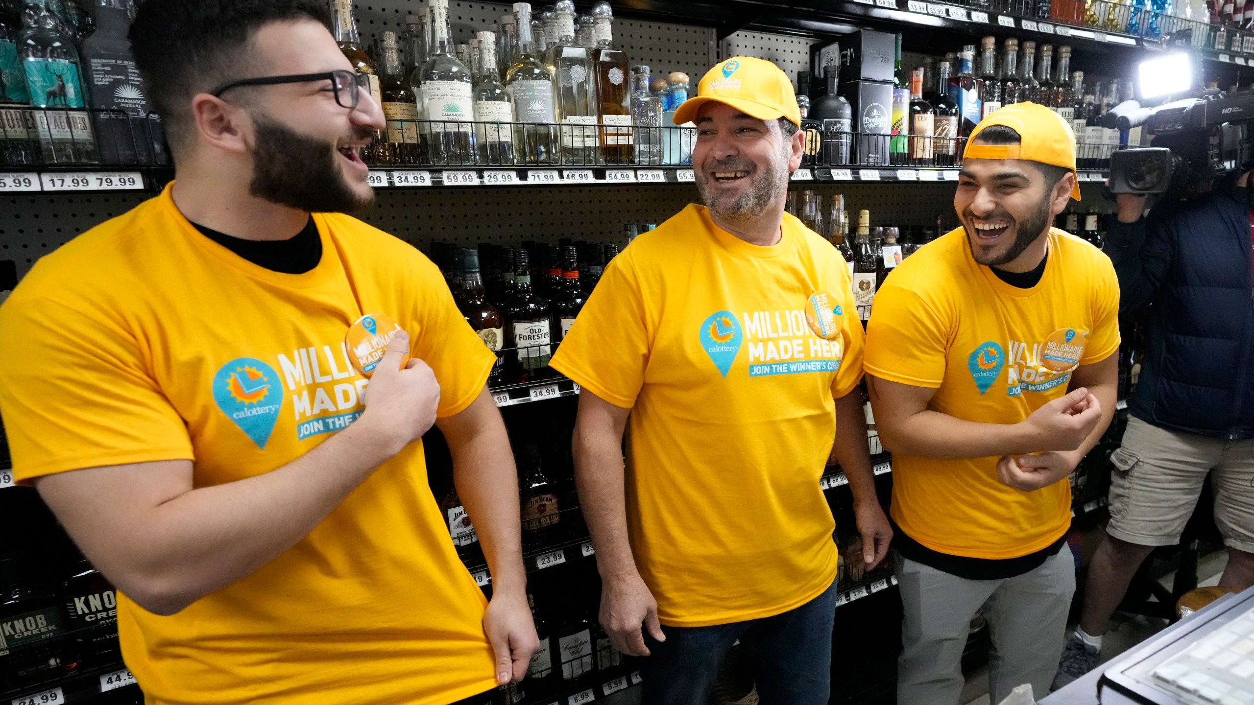 Store co-owner Nidal Khalil, center, smiles with son Jonathan Khalil, left, and nephew Chris Khalil, right, after putting on T-shirts at the Midway Market & Liquor store, Thursday, Oct. 12, 2023, in Frazier Park, Calif., where a winning Powerball lottery ticket was sold. A player in California won a $1.765 billion Powerball jackpot Wednesday night, ending a long stretch without a winner of the top prize. (AP Photo/Marcio Jose Sanchez)