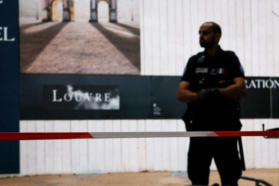 A police officer stands guard outside the Louvre Museum as people are evacuated after it received a written threat, in Paris, Saturday Oct. 14, 2023. The Louvre Museum says it is closing for the day and evacuating all visitors and staff after a threat. (AP Photo/Thomas Padilla)