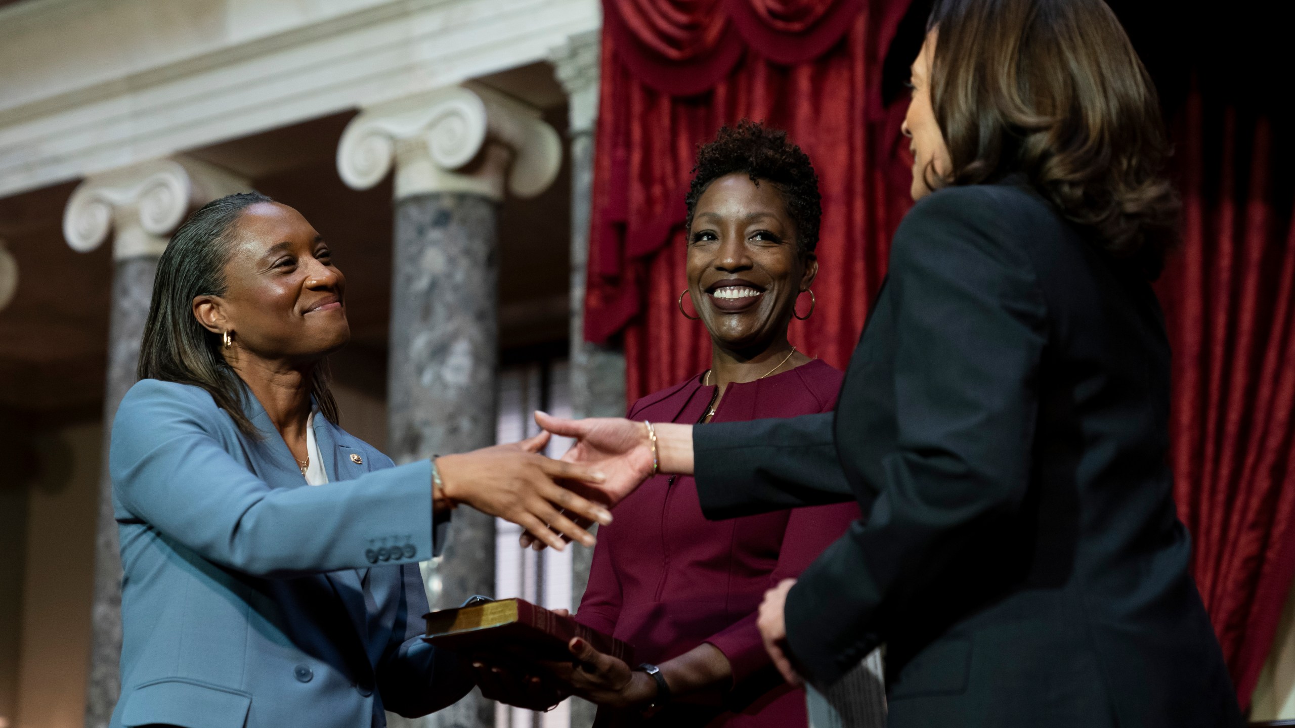 Vice President Kamala Harris, right, swears in Laphonza Butler, D-Calif., left, to the Senate to succeed the late Sen. Dianne Feinstein during a re-enactment of the swearing-in ceremony on Tuesday, Oct. 3, 2023, on Capitol Hill in Washington. Butler's wife, Neneki Lee, center, holds the Bible. (AP Photo/Stephanie Scarbrough)