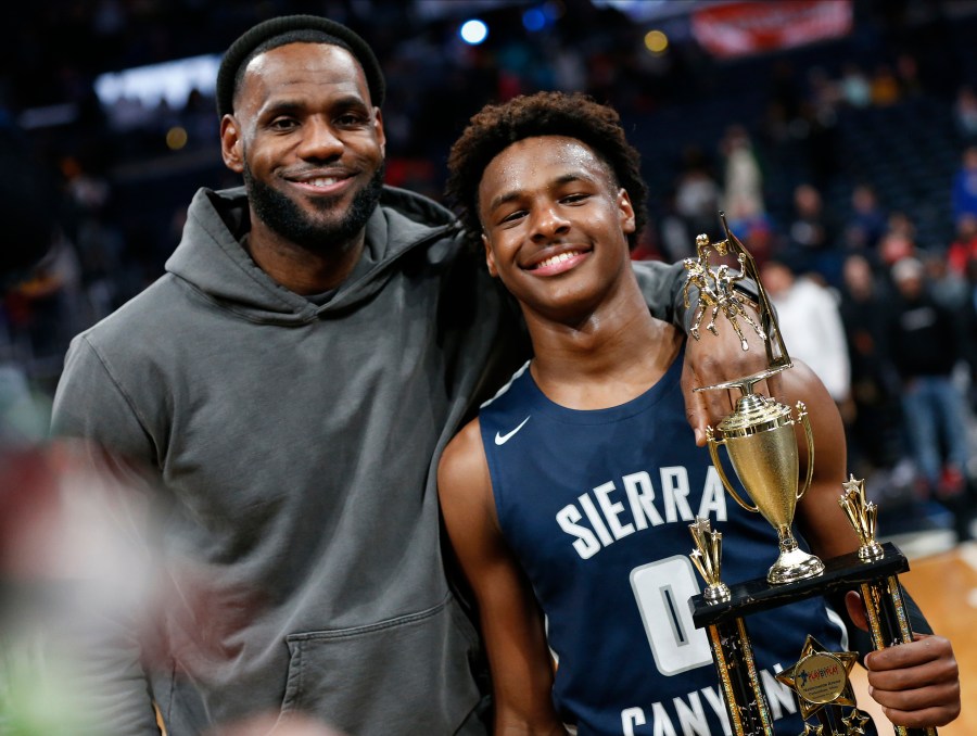 FILE - Los Angeles Lakers forward LeBron James, left, poses with his son Bronny after Sierra Canyon defeated Akron St. Vincent-St. Mary in a high school basketball game Dec. 14, 2019, in Columbus, Ohio. Bronny James joined his Southern California teammates in a preseason fan event at Galen Center, Thursday, Oct. 19, 2023. (AP Photo/Jay LaPrete, File)