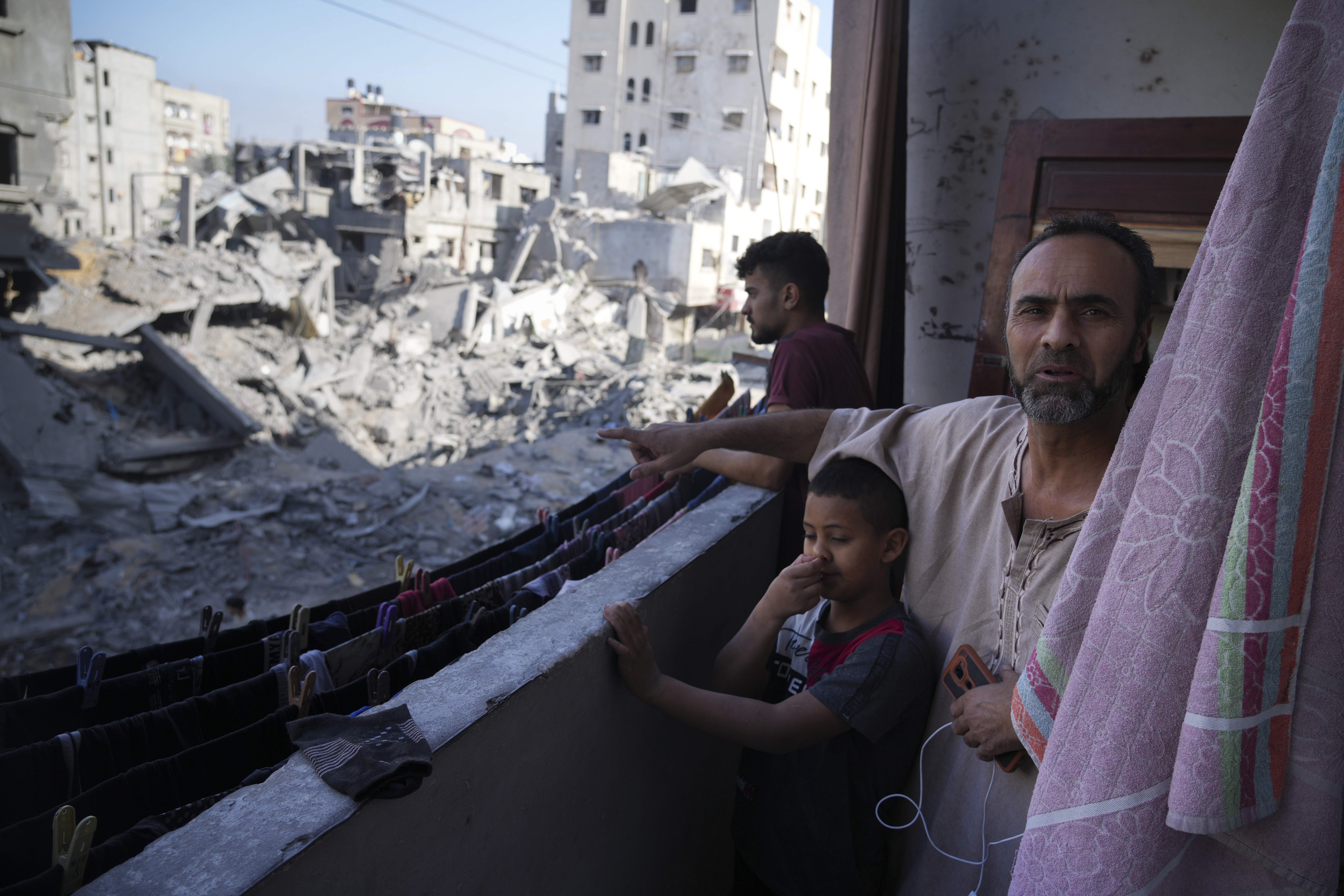 Palestinian points at destruction by the Israeli bombardment of the Gaza Strip in the Maghazi refugee camp, Friday, Nov. 3, 2023. (AP Photo/Hatem Moussa)