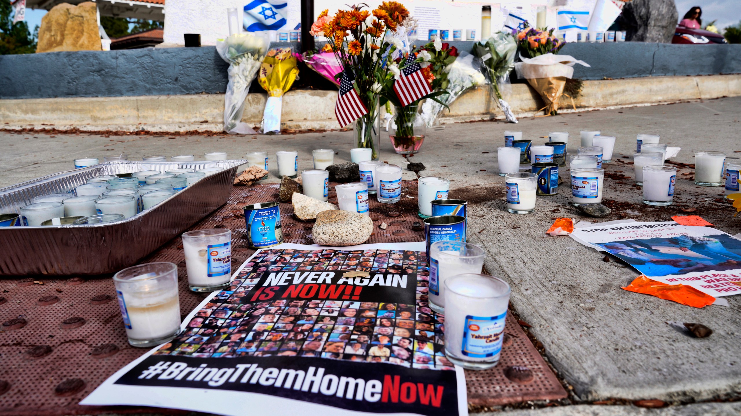 Flowers and candles are left at a makeshift shrine placed at the scene of a Sunday confrontation that lead to death of a demonstrator, Tuesday, Nov. 7, 2023, in Thousand Oaks, Calif. Paul Kessler, 69, died at a hospital on Monday from a head injury after witnesses reported he was involved in a "physical altercation" during pro-Israel and pro-Palestinian demonstrations at an intersection in Thousand Oaks, a suburb northwest of Los Angeles, authorities said. (AP Photo/Richard Vogel)