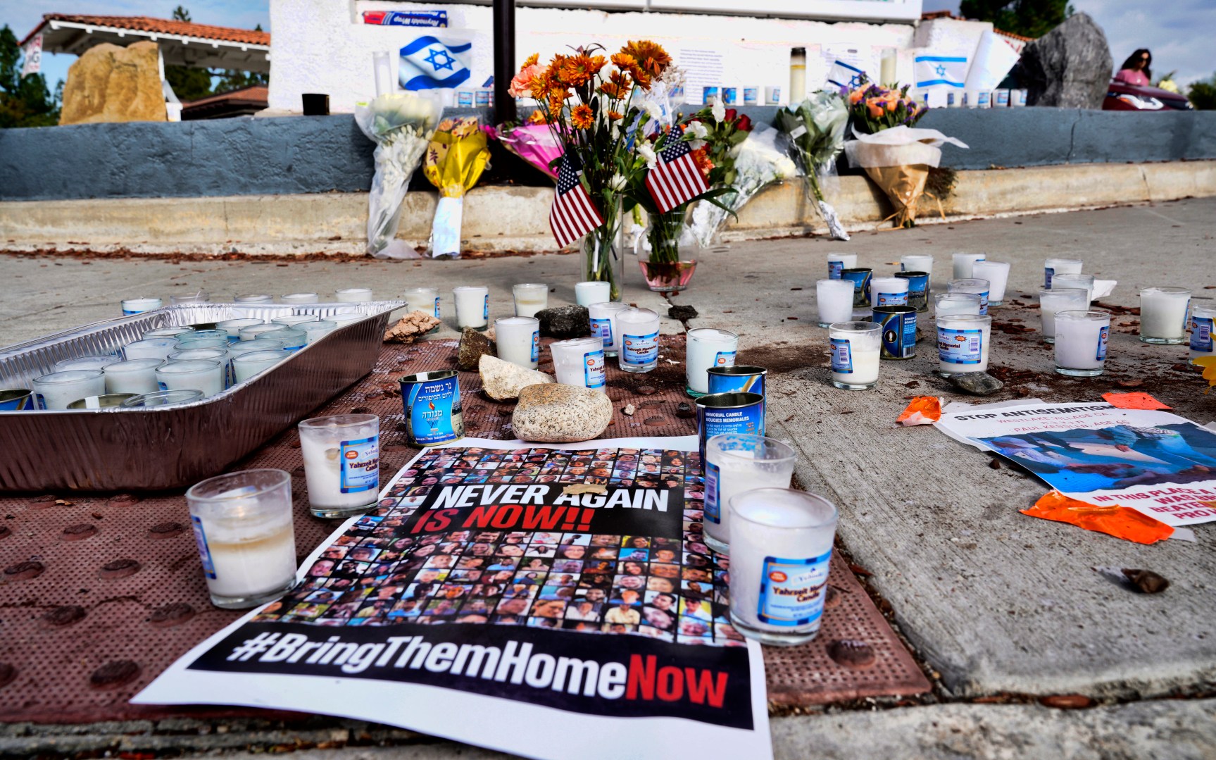 Flowers and candles are left at a makeshift shrine placed at the scene of a Sunday confrontation that lead to death of a demonstrator, Tuesday, Nov. 7, 2023, in Thousand Oaks, Calif. Paul Kessler, 69, died at a hospital on Monday from a head injury after witnesses reported he was involved in a "physical altercation" during pro-Israel and pro-Palestinian demonstrations at an intersection in Thousand Oaks, a suburb northwest of Los Angeles, authorities said. (AP Photo/Richard Vogel)