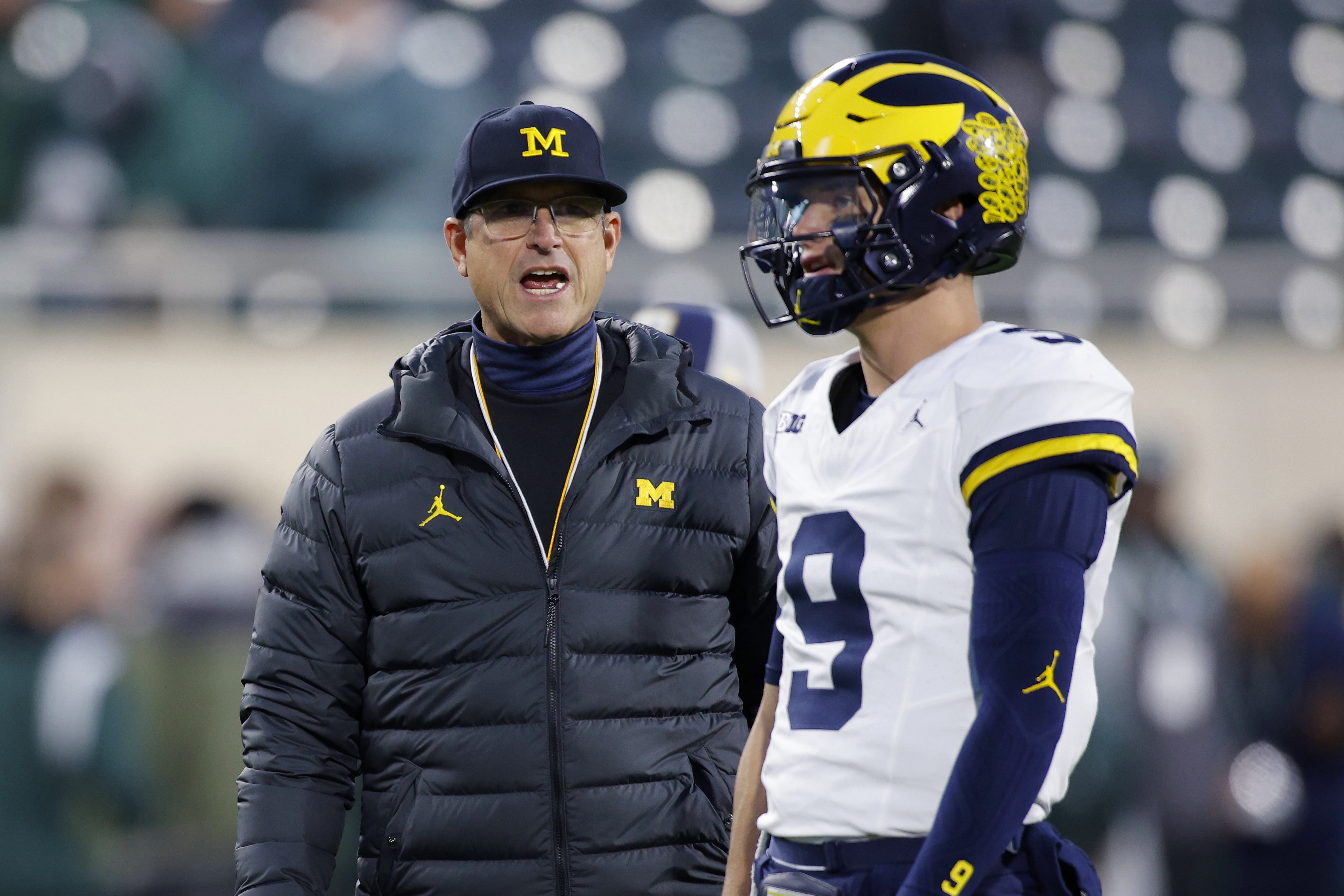 Michigan coach Jim Harbaugh, left, talks to quarterback J.J. McCarthy before an NCAA college football game against Michigan State, Saturday, Oct. 21, 2023, in East Lansing, Mich. (AP Photo/Al Goldis)