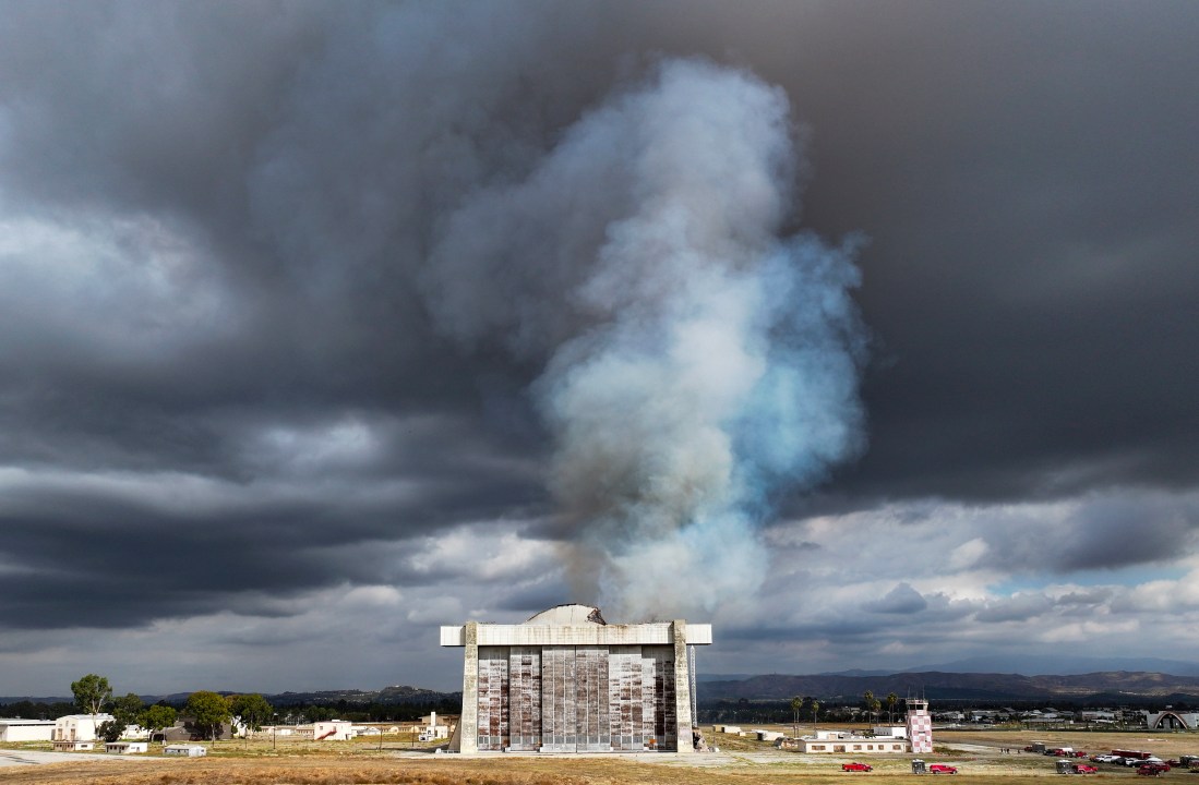 Firefighters work to control a blaze at the north blimp hangar at the former Marine Corps Air Station Tustin in Tustin, Calif., on Tuesday, Nov. 7, 2023. (Jeff Gritchen/The Orange County Register via AP)