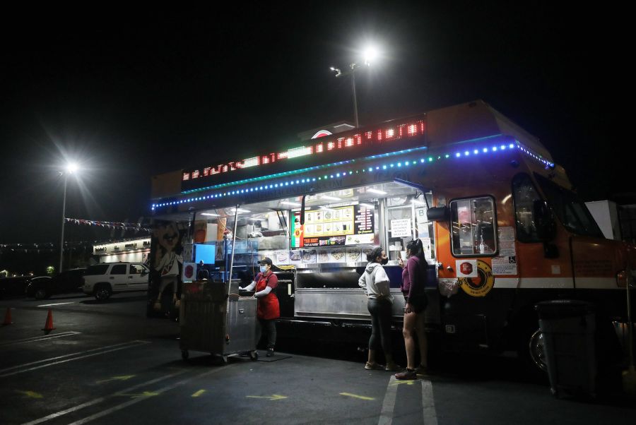 Customers order from a taco truck on July 1, 2020 in Los Angeles, California. (Photo by Mario Tama/Getty Images)