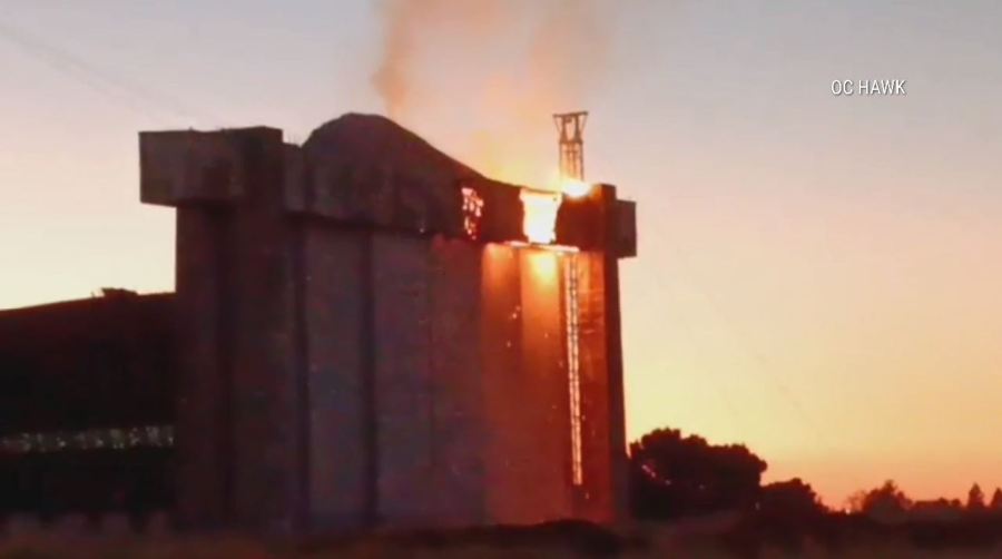 An active flare-up of a fire seen on the doors of a historic airbase hangar in Tustin on Nov. 11 has prompted concerns from residents. (OC Hawk)