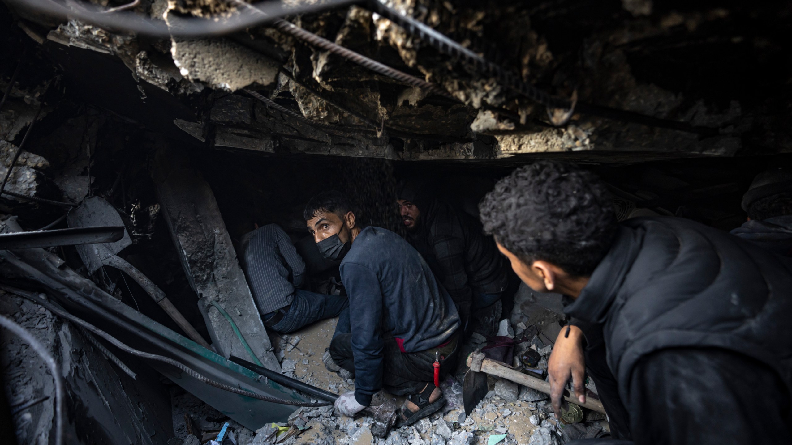 Palestinians search for bodies and survivors in the rubble of a residential building destroyed in an Israeli airstrike, in Rafah, southern Gaza Strip, Friday, Dec. 15, 2023. (AP Photo/Fatima Shbair)