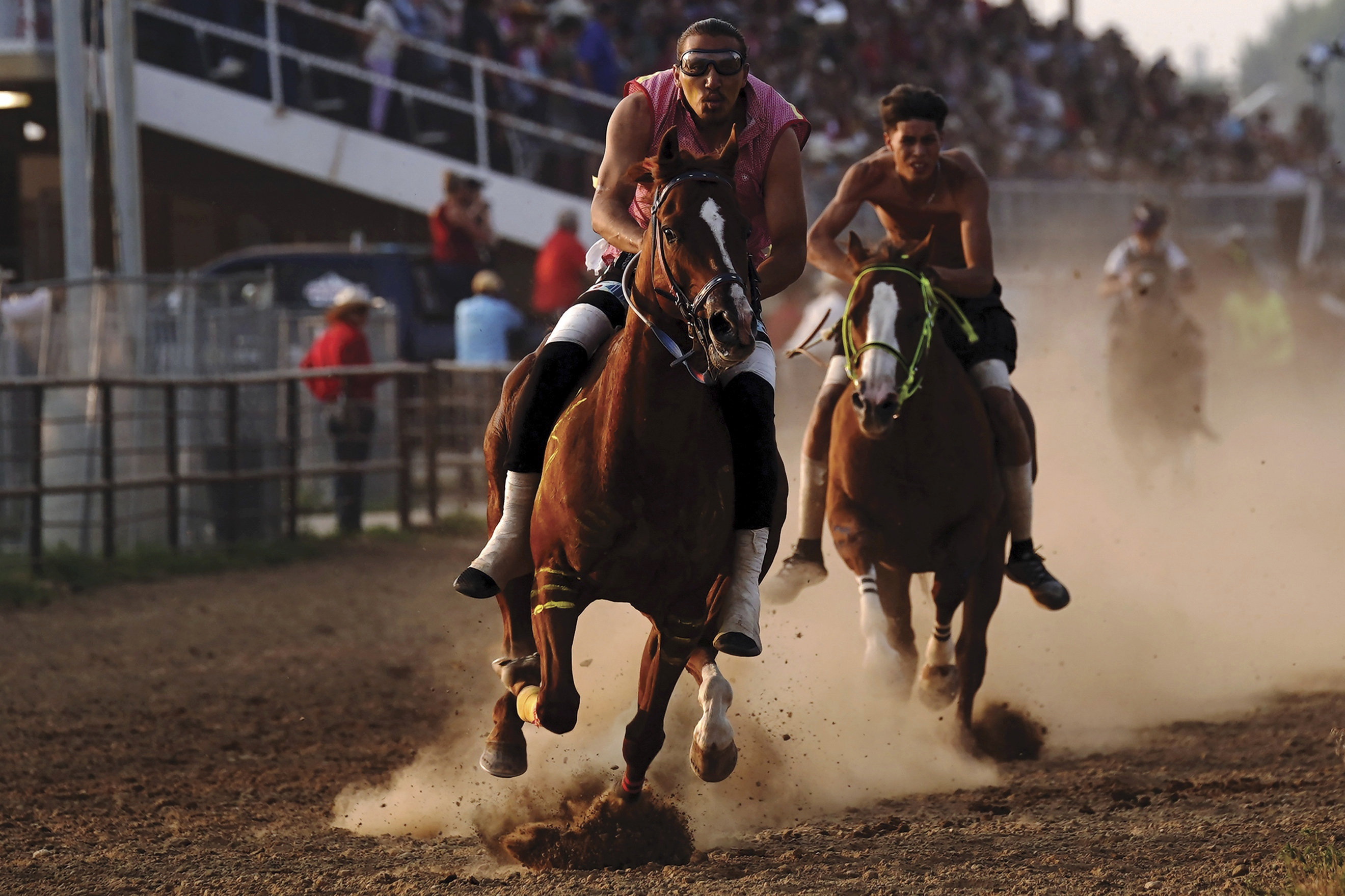 S/M Express' Desmond Archilta, right, competes during the second heat of the World Championship Indian Relay Race during the Sheridan WYO Rodeo, Friday, July 14, 2023, in Sheridan, Wy. Born out of necessity and in mastering skills that came as horses transformed hunting, travel and warfare, rodeo has remained popular in Native American communities. Grandstands often play host to mini family reunions while Native cowboys and cowgirls show off their skills roping, riding and wrestling livestock. (Matt Gaston/Sheridan Press via AP)