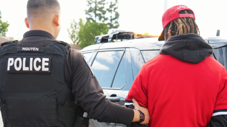 A person is detained after police bust a "sesh" business in San Bernardino on December 21, 2023.