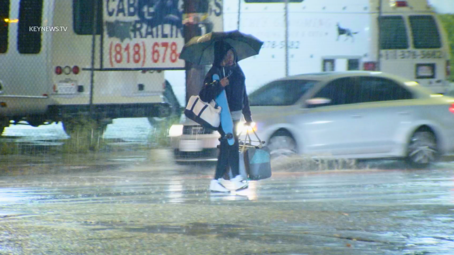 Rain falls on a pedestrian in Van Nuys on Dec. 22, 2023.