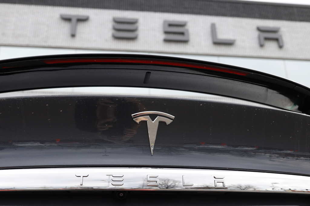 The Tesla company logo shines off the rear deck of an unsold 2020 Model X at a Tesla dealership, April 26, 2020.