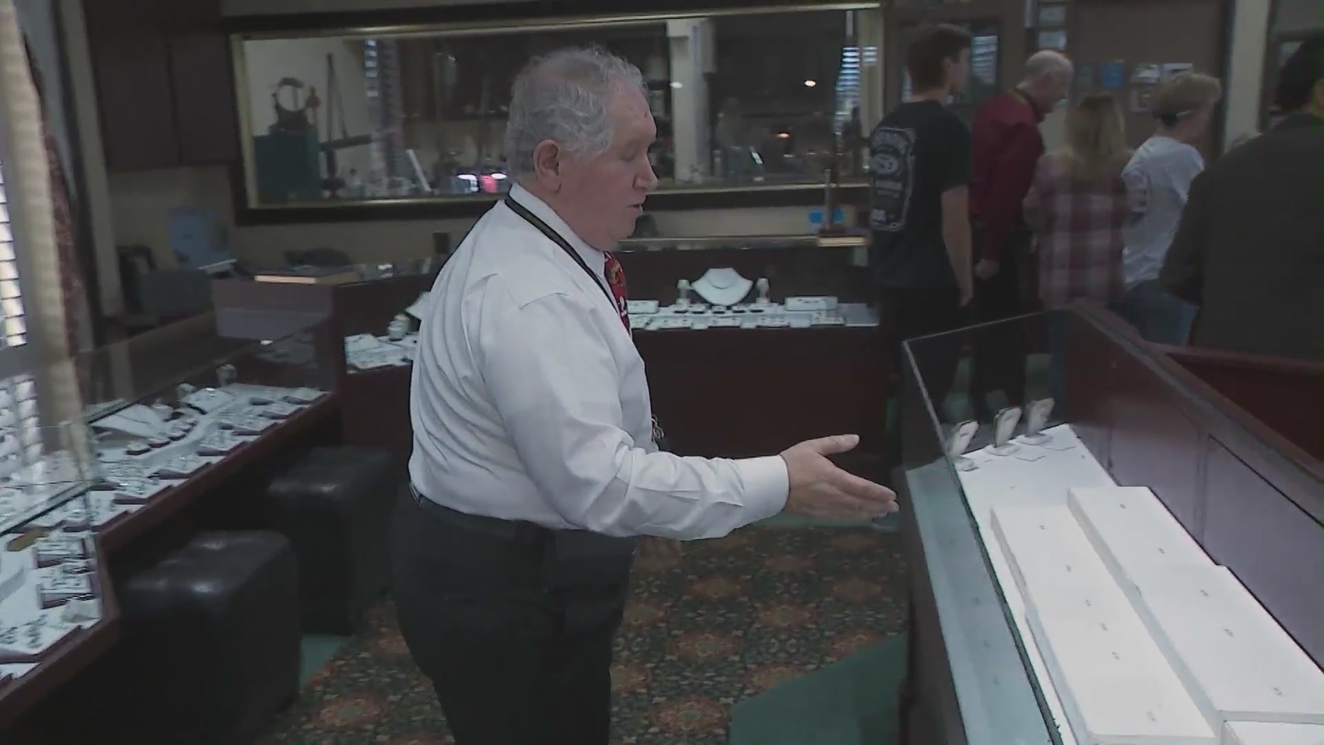 The owner of Ozel Jewelers showing empty display cases after five thieves escaped with thousands of dollars worth of jewelry on Dec. 19, 2023. (KTLA)