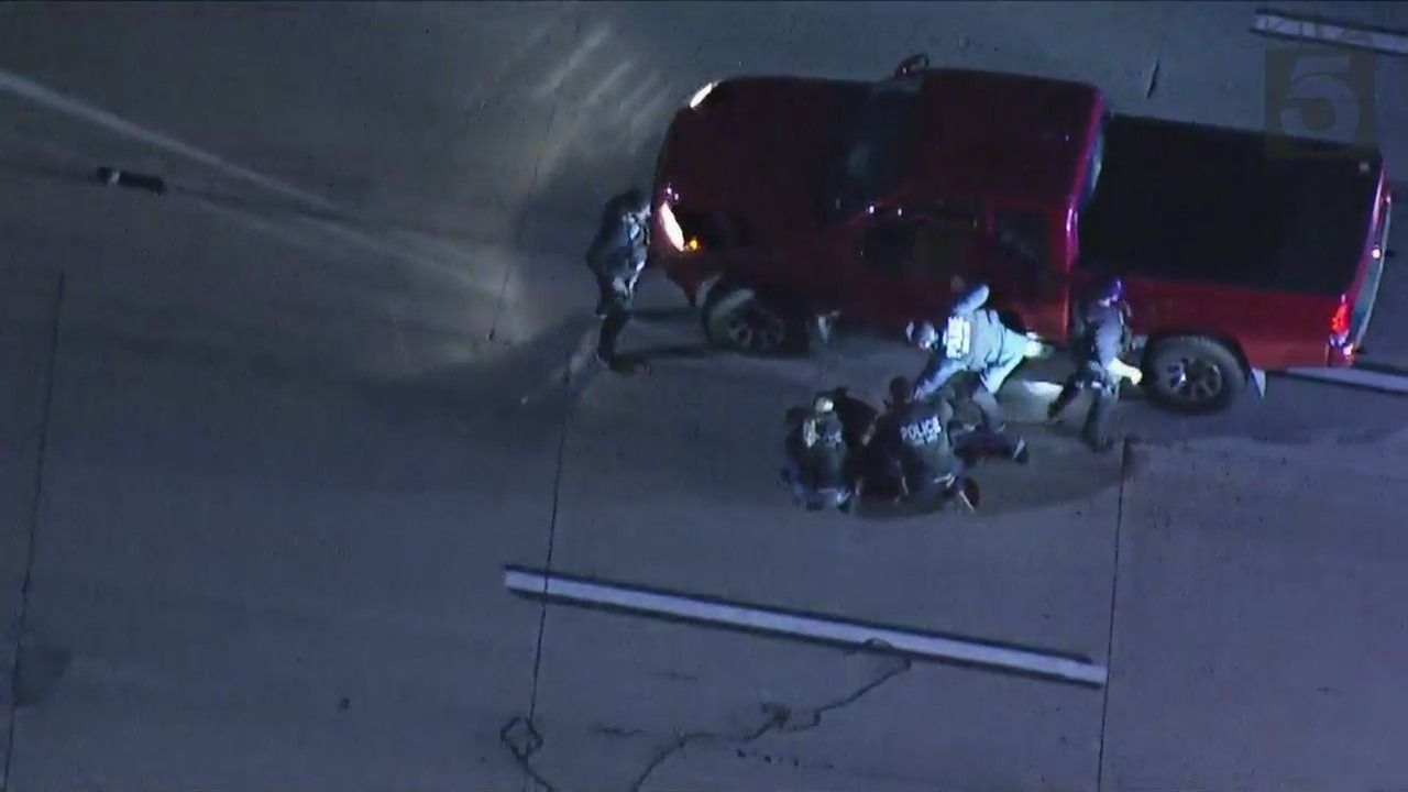 Officers tackling the suspect after he quickly turned his head toward officers while being arrested following a pursuit on Dec. 7, 2023. (KTLA)