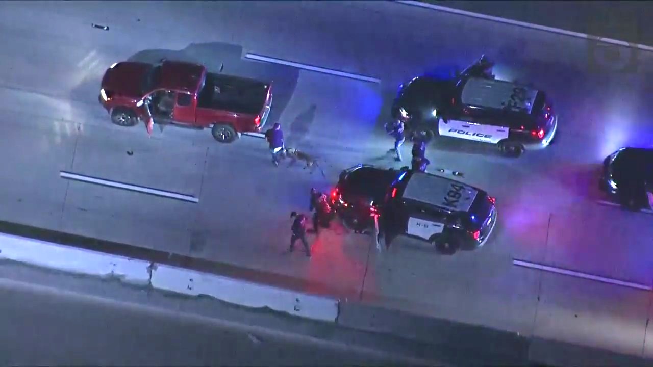 Fontana police K-9 tackling the suspect after he quickly turned his head toward officers while being arrested following a pursuit on Dec. 7, 2023. (KTLA)