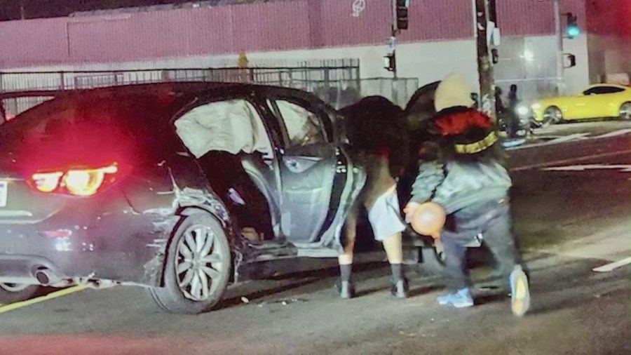 Stolen vehicle suspects seen fleeing the destroyed car while holding a balloon typically used for inhaling nitrous oxide on Jan. 3, 2024. 