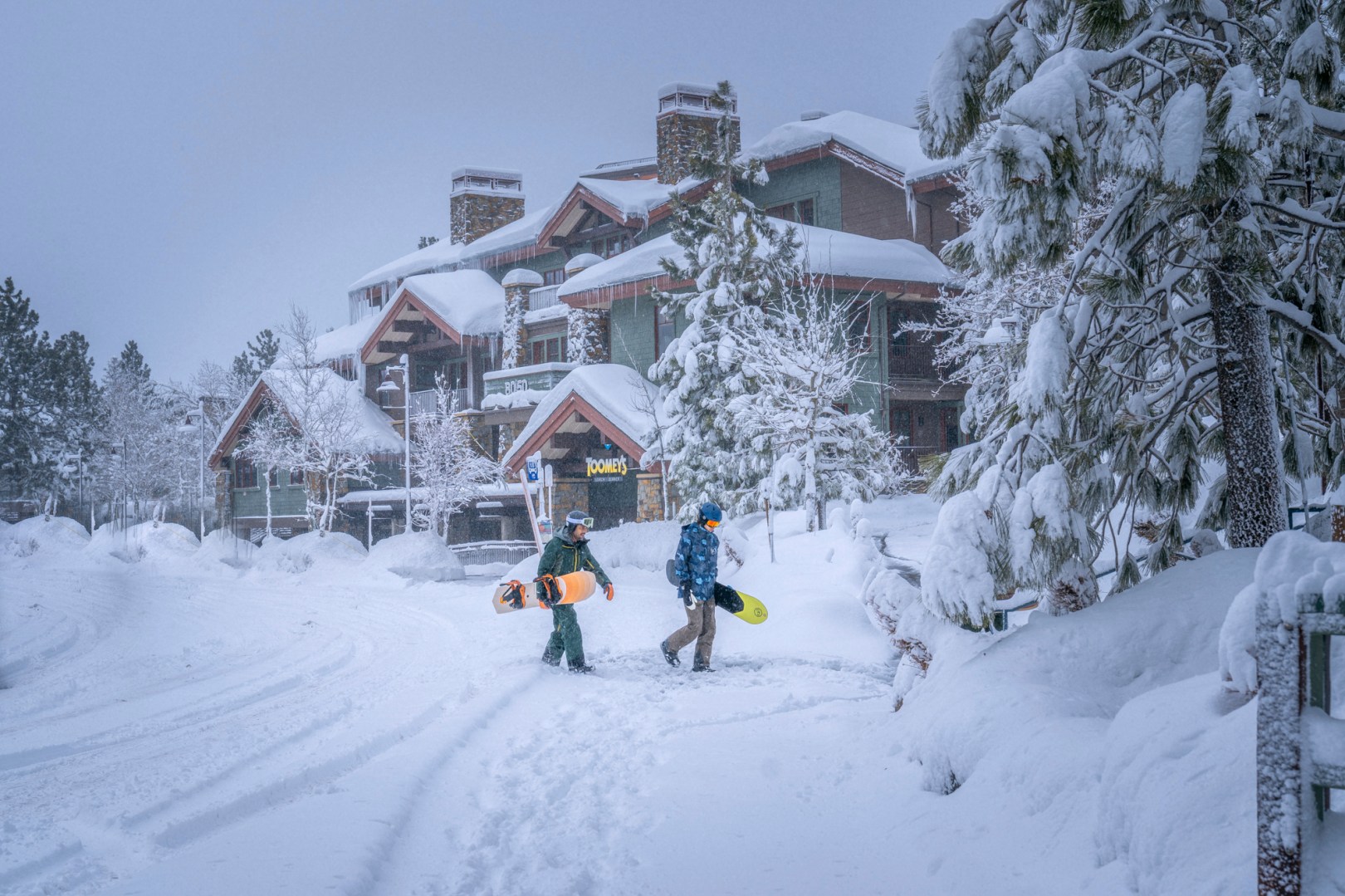 In this photo provided by Mammoth Lakes Tourism, snowboarders walk in the snow on Monday, Feb. 19, 2024, in Mammoth Lakes, Calif. (Jacob Myhre/Mammoth Lakes Tourism via AP)