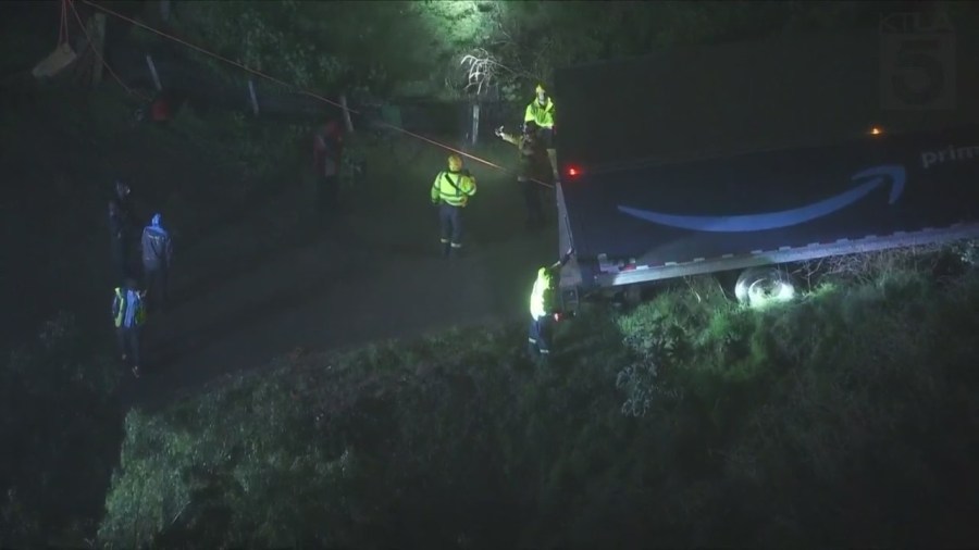 Amazon delivery truck stuck on hillside, threatening home below