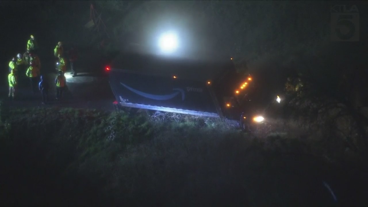 Amazon delivery truck stuck on hillside, threatening home below