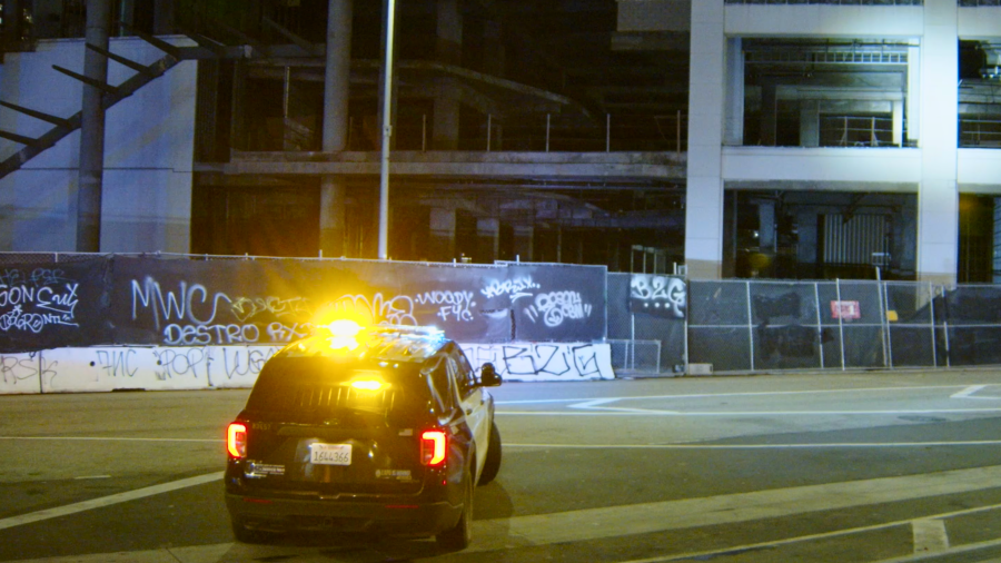 An LAPD unit patrols a graffiti-covered skyscraper in downtown Los Angeles on Feb. 9, 2024.