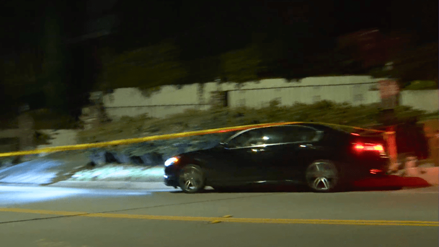 A car is seen passing through caution tape on Coldwater Canyon Drive before almost crashing into a downed tree.