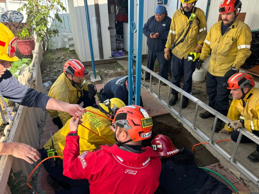 Rescue crews work to rescue a woman trapped in a sinkhole in Fontana on Feb. 8, 2024.