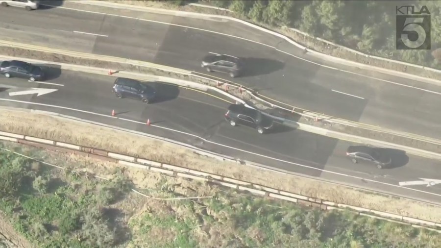 Aerial footage from Feb. 15, 2024, shows cars travel over Rancho Palos Verdes Drive, which was left bulging from an ongoing landslide. 