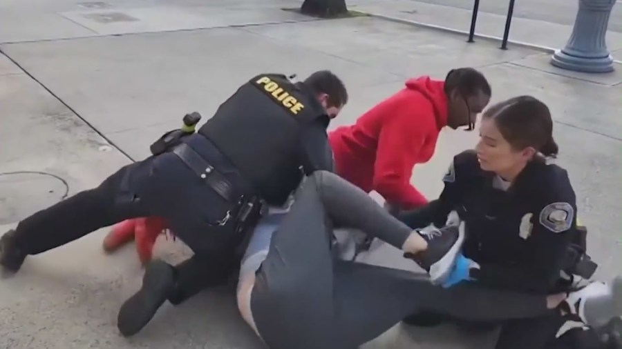 The moment officers chase a suspected child predator through a Carl's Jr. restaurant in Long Beach with the help of “Black Biden,” seen in the red hoodie. (@black_biden8383)