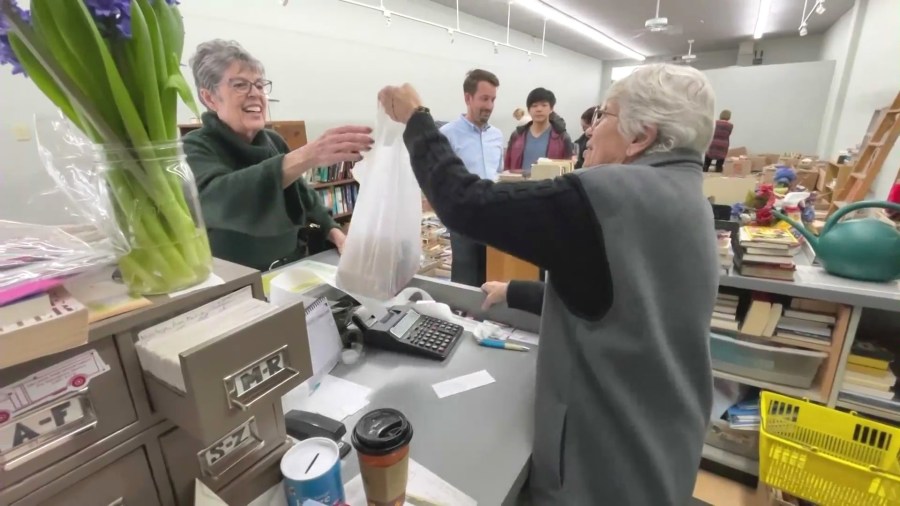 Karen Kropp sells books to a loyal customer at The Book Rack before closing up shop after over 40 years of operation on Feb. 27, 2024. (KTLA)