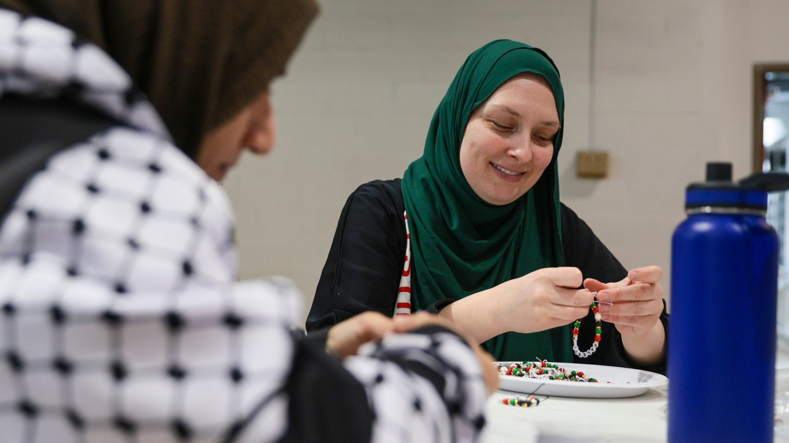 Melissa Saunders ties loose bracelets for her daughter's fundraiser for children affected by the war in Gaza at the Dar Al Jalal Masjid Mosque in Hazelwood, Mo. on Saturday, March 2, 2024. Saunders's daughter is part of former Girl Scout Troop 149 which left the organization after being told to stop their fundraiser by the regional Girl Scout council. (Vanessa Abbitt/St. Louis Post-Dispatch via AP)