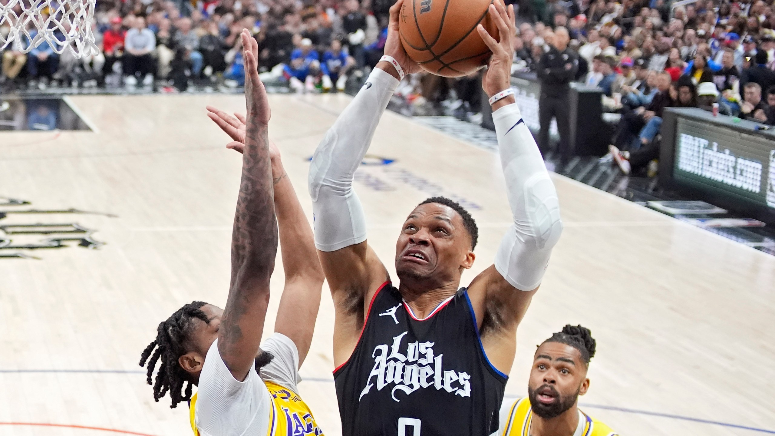 Los Angeles Clippers guard Russell Westbrook, center, shoots as Los Angeles Lakers forward Cam Reddish, left, and guard D'Angelo Russell defend during the second half of an NBA basketball game Wednesday, Feb. 28, 2024, in Los Angeles. (AP Photo/Mark J. Terrill)