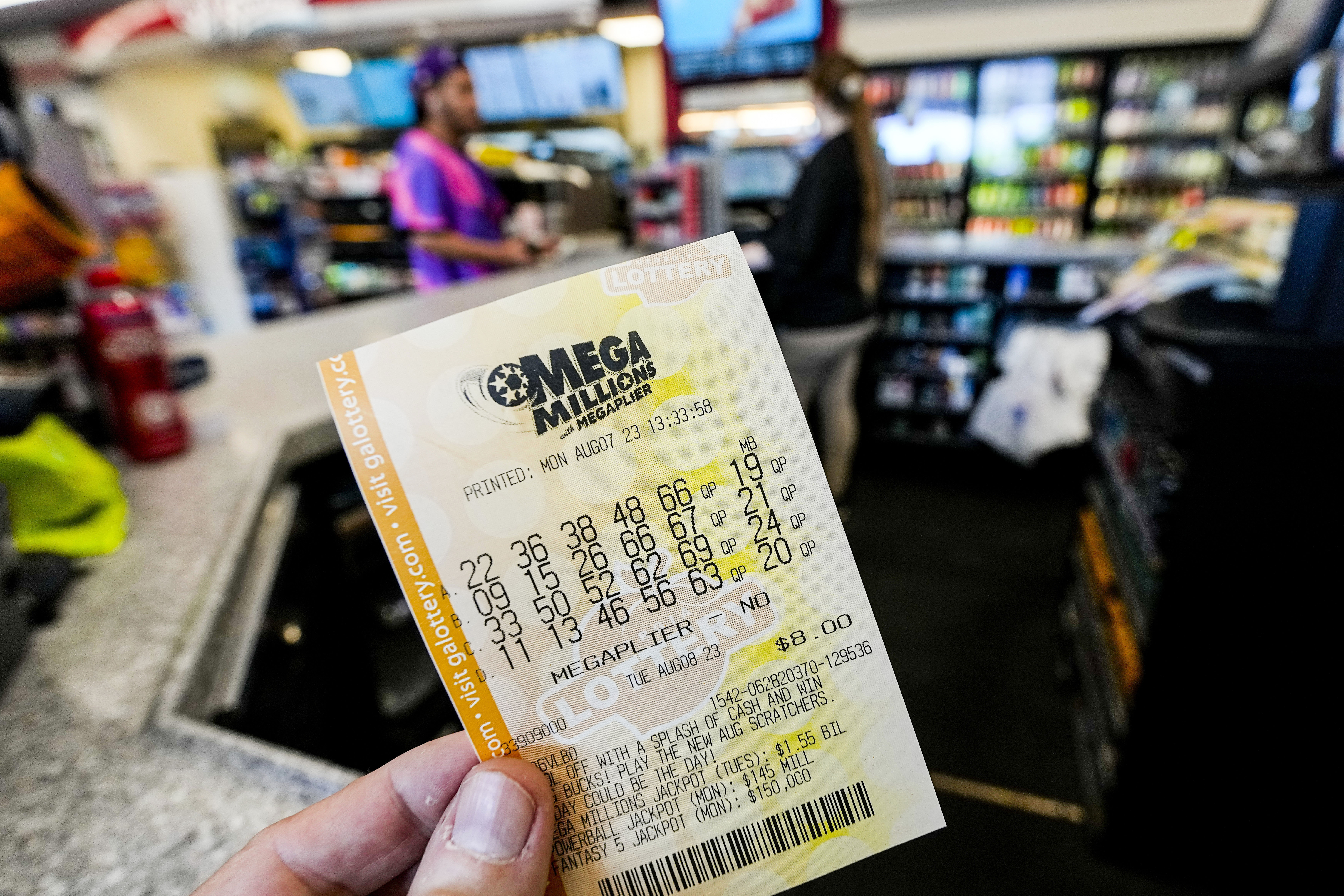 FILE - A Mega Millions ticket is seen as a person makes a purchase inside a convenience store, Aug. 7, 2023, in Kennesaw, Ga. Someone in New Jersey overcame the odds and won the $1.13 billion Mega Millions jackpot, breaking a winless streak that dated to last December. The numbers drawn Tuesday night, March 26, 2024, were: 7, 11, 22, 29, 38 and the gold Mega Ball 4. (AP Photo/Mike Stewart, File)