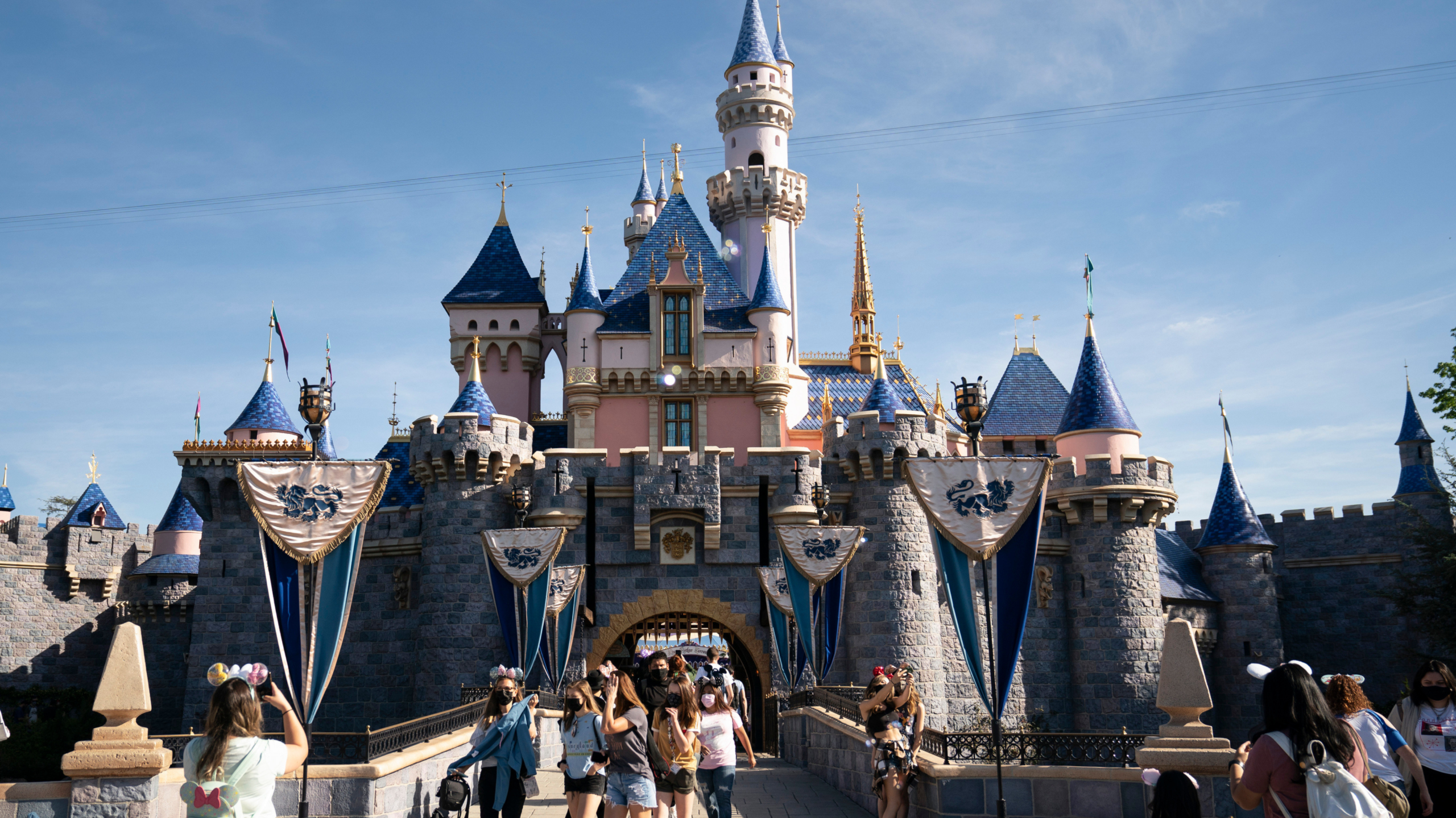 This file photo shows visitors pass through Disneyland in Anaheim, Calif., April 30, 2021.