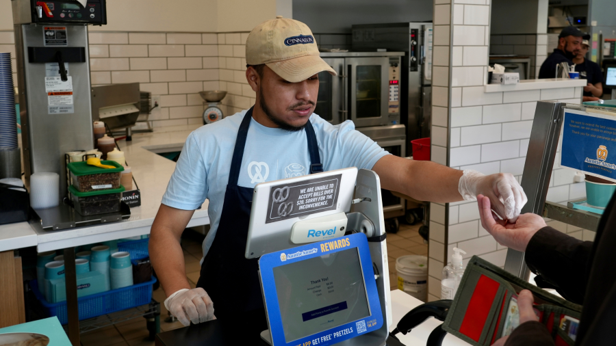 An employee collects payment at an Auntie Anne's and Cinnabon store in Livermore, Calif., Thursday, March 28, 2024.