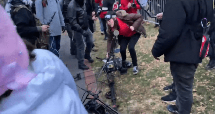 A photo shared by the FBI allegedly shows Kayla Reifschneider damaging camera equipment at the Jan. 6, 2021 riot at the U.S. Capitol