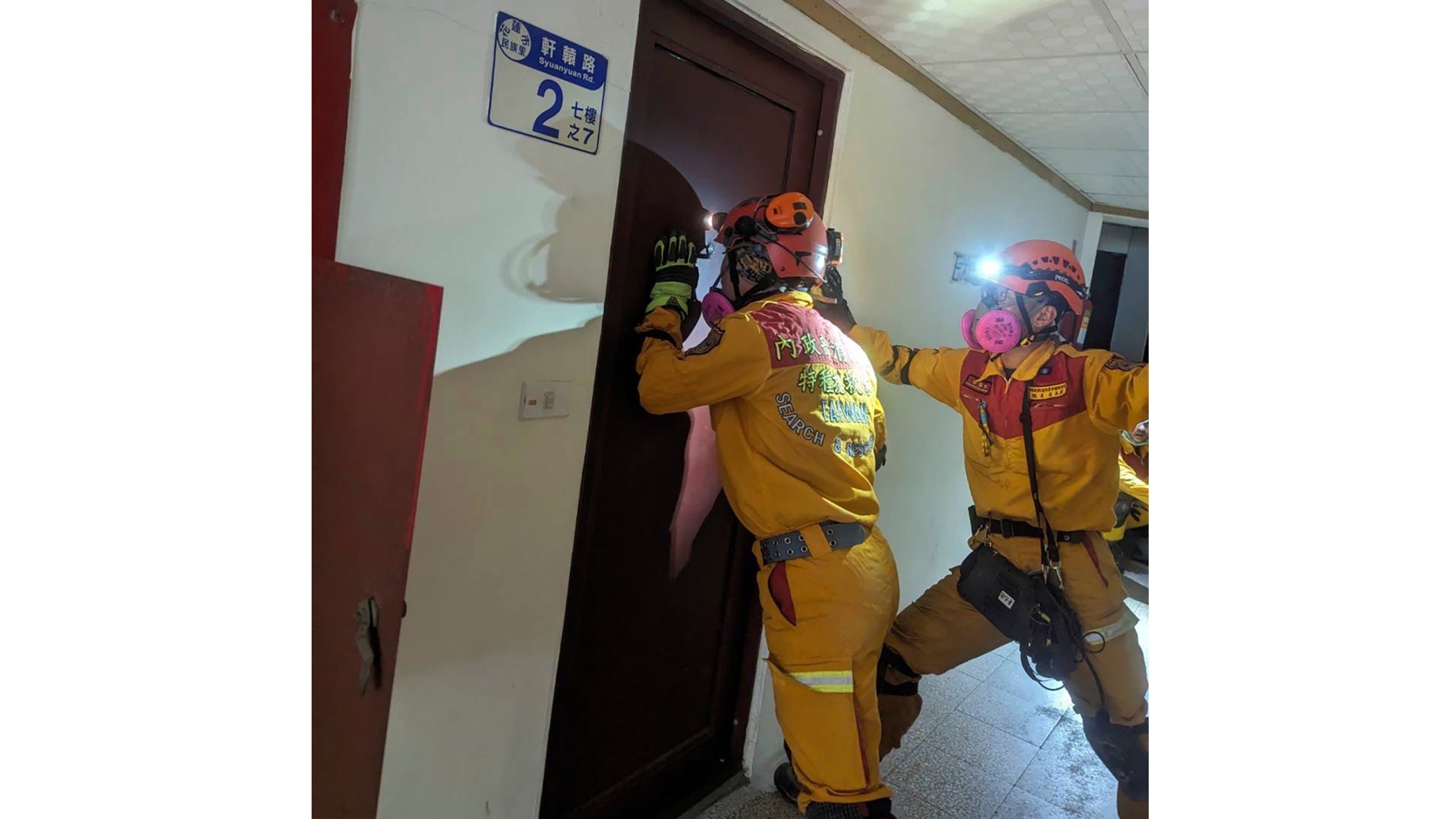 In this photo released by the National Fire Agency, members of a search and rescue team look for victims inside a leaning building in the aftermath of an earthquake in Hualien, eastern Taiwan on Wednesday, April 3, 2024. Taiwan's strongest earthquake in a quarter century rocked the island during the morning rush Wednesday, damaging buildings and creating a tsunami that washed ashore on southern Japanese islands. (National Fire Agency via AP)
