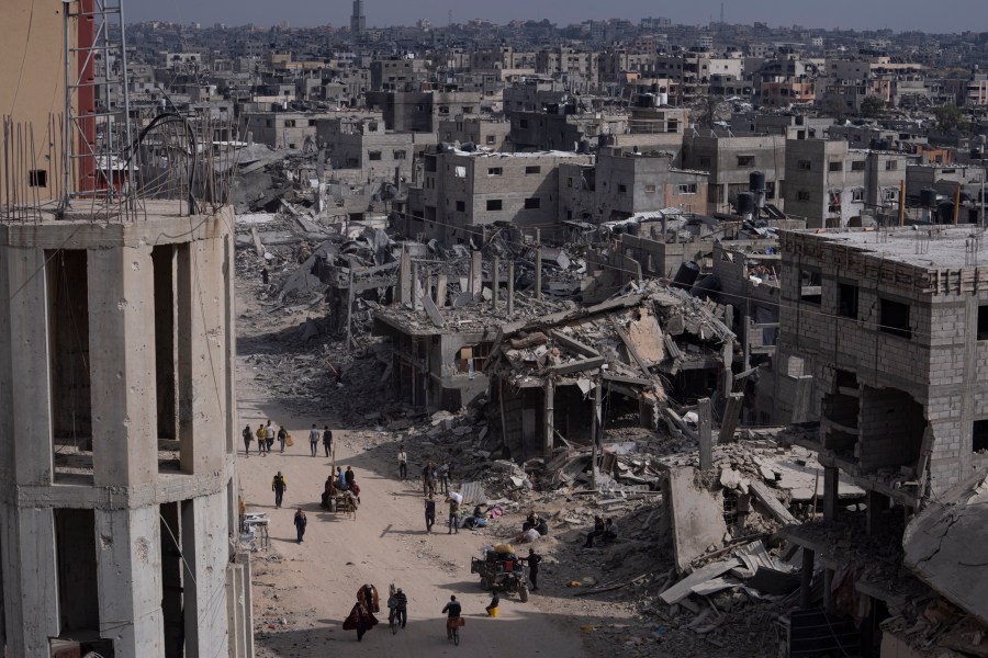 Palestinians walk through the destruction in the wake of an Israeli air and ground offensive in Khan Younis, southern Gaza Strip, Monday, April 8, 2024. Israel says it has withdrawn its last ground troops from the city, ending a four-month operation. (AP Photo/Fatima Shbair)