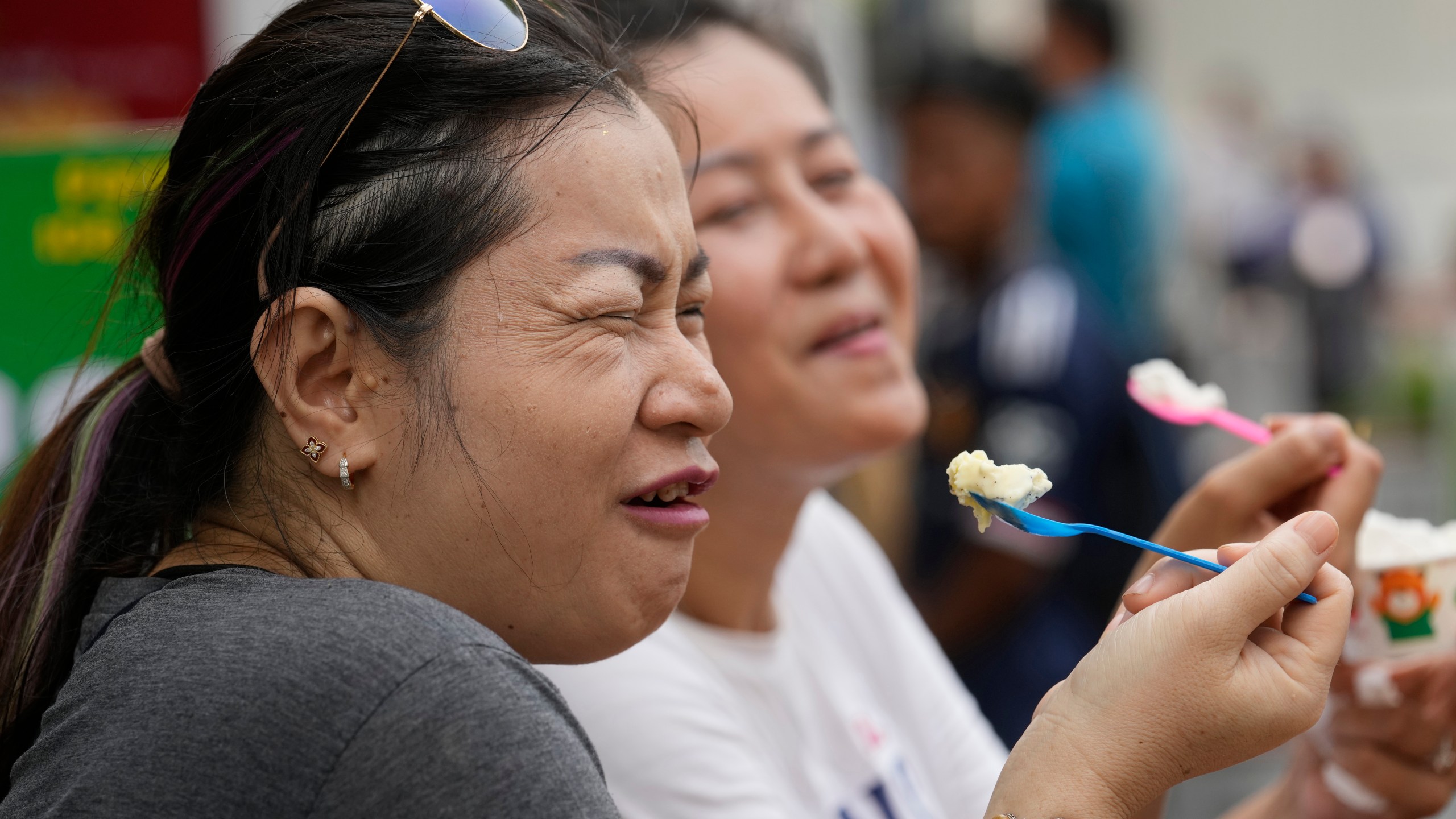 Women enjoy ice cream in Bangkok, Thailand, Tuesday, April 9, 2024. Thailand, Cambodia and other countries in this region are celebrating with their annual water festivals as they also suffer through the global heat wave. (AP Photo/Sakchai Lalit)