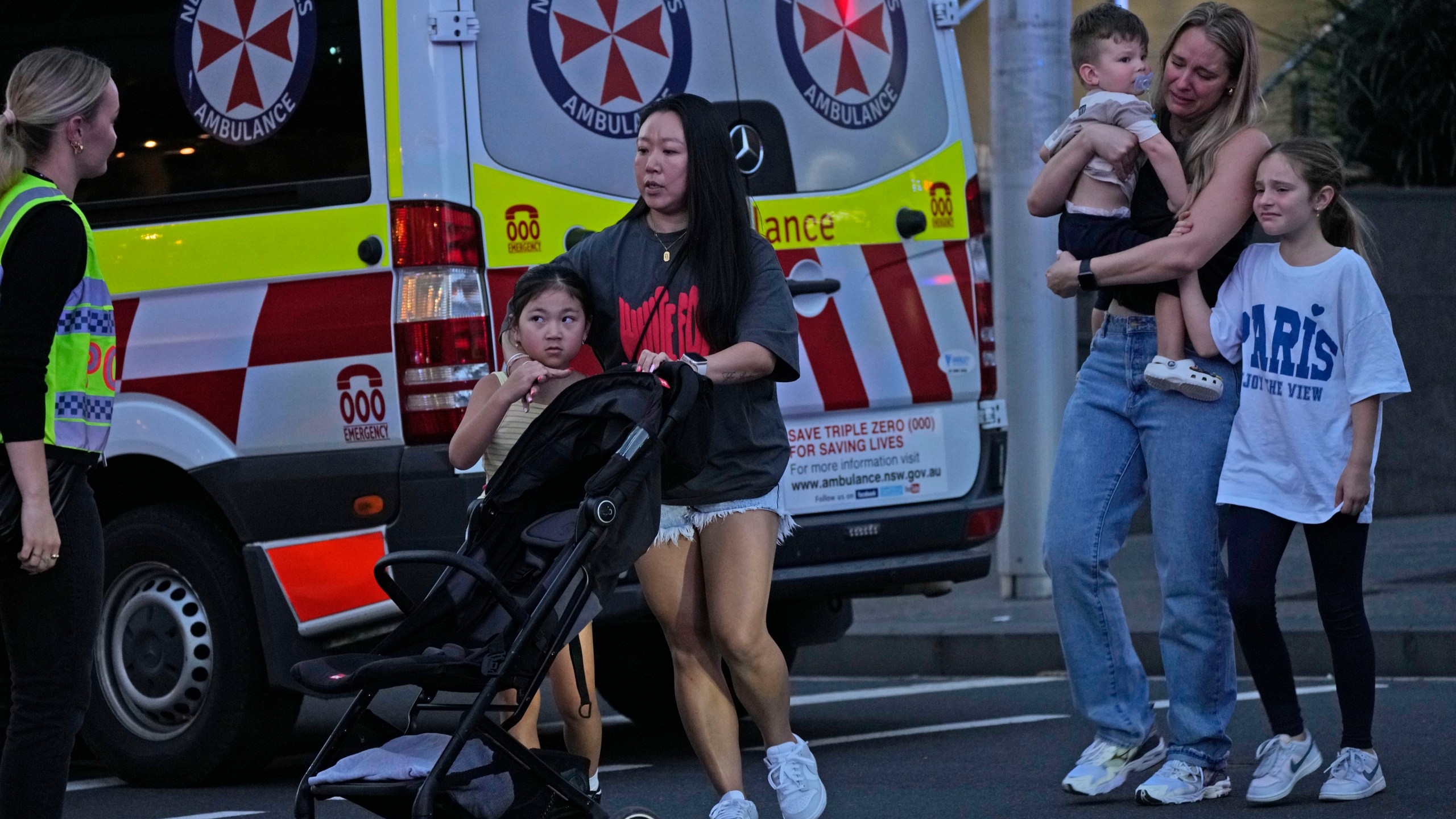 People are led out from the Westfield Shopping Centre where multiple people were stabbed in Sydney, Saturday, April 13, 2024. A man stabbed six people to death at the busy Sydney shopping center Saturday before he was fatally shot, police said. Multiple people, including a small child, were also injured in the attack. (AP Photo/Rick Rycroft)