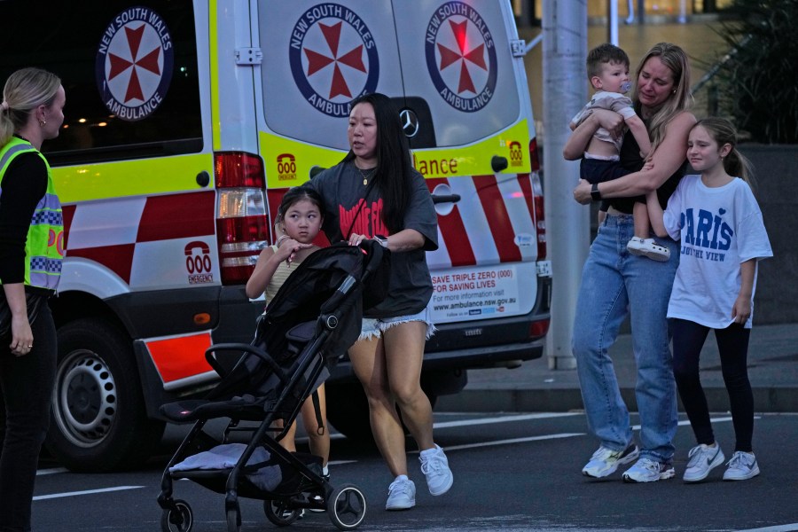 People are led out from the Westfield Shopping Centre where multiple people were stabbed in Sydney, Saturday, April 13, 2024. A man stabbed six people to death at the busy Sydney shopping center Saturday before he was fatally shot, police said. Multiple people, including a small child, were also injured in the attack. (AP Photo/Rick Rycroft)