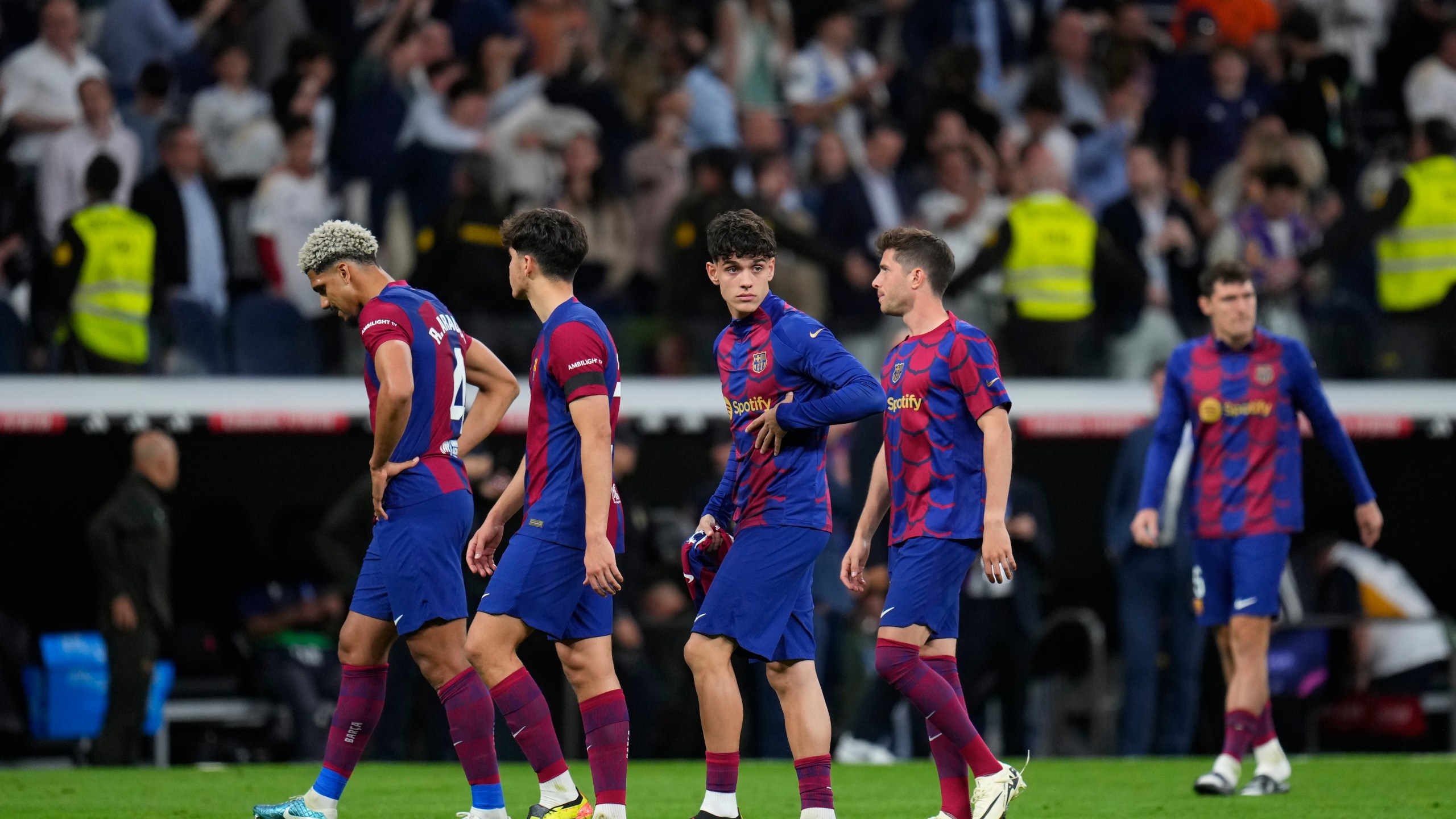 Barcelona players react as they leave the field at the end of the Spanish La Liga soccer match between Real Madrid and Barcelona at the Santiago Bernabeu stadium in Madrid, Spain, Sunday, April 21, 2024. (AP Photo/Manu Fernandez)