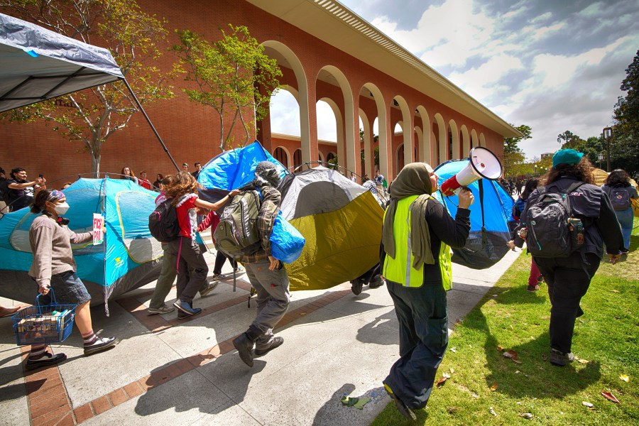 University of Southern California protesters carry a tents around Alumni Park on the University of Southern California to keep security from removing them during a pro-Palestinian occupation on Wednesday, April 24, 2024 in Los Angeles. (AP Photo/Richard Vogel)